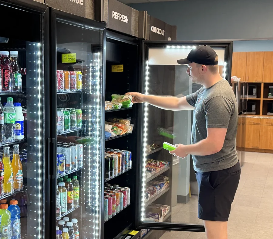 Employee grabbing a fresh meal from a micro market cooler