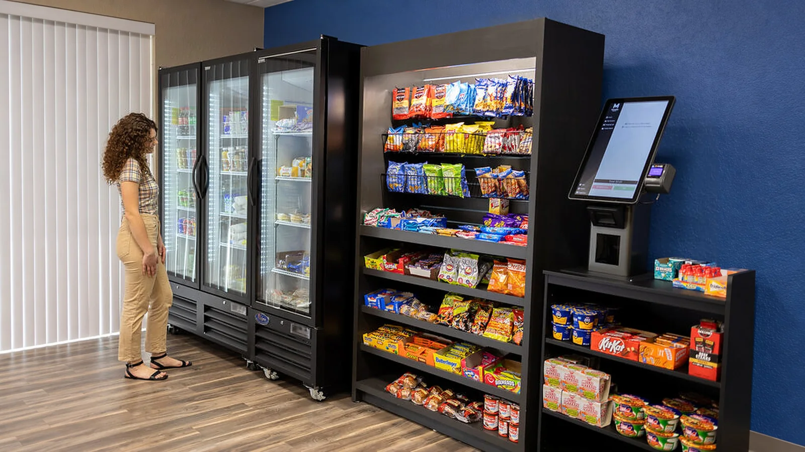 Employee browsing a micro market with a self-checkout kiosk