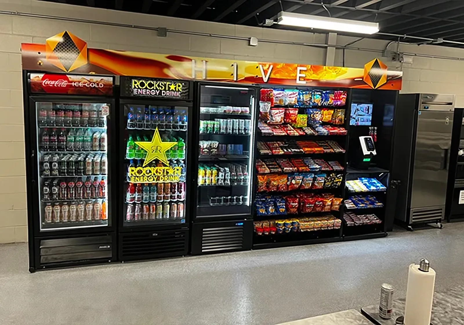 Micro market with drink coolers, snacks and a checkout kiosk