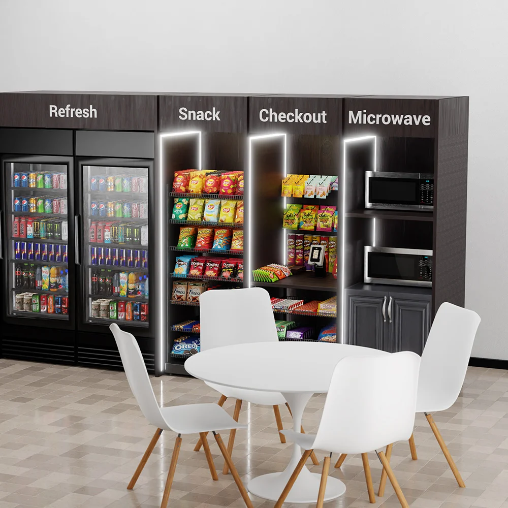 Self-service micro market with refreshment coolers, snack shelves, checkout kiosk and microwaves, plus seating area.